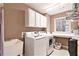 Spacious laundry room complete with washer, dryer, sink and ample counter space for folding laundry at 1525 Haddenham Dr, Cumming, GA 30041