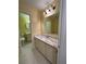Bathroom features marble countertops, white cabinets, neutral paint, gray tile floors, and a large mirror at 22 Cardinal Ln, Jonesboro, GA 30238