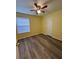 This bedroom has gray wood floors, a ceiling fan, a window with blinds and yellow walls at 22 Cardinal Ln, Jonesboro, GA 30238