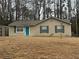 Charming single-story home features a manicured lawn and a delightful blue front door at 22 Cardinal Ln, Jonesboro, GA 30238