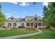 Inviting home featuring a brick walkway, manicured lawn, a covered porch, and lush landscaping at 101 Barker Rd, Cumming, GA 30040