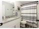 Clean bathroom with granite countertop, white cabinets, and a striped shower curtain at 25 Water Oak Trl, Covington, GA 30014