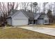 Gray house with a gray roof, white garage door, and a long driveway at 25 Water Oak Trl, Covington, GA 30014