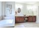 Bathroom featuring a tub and dual vanity sinks with wooden cabinets at 342 Holbrook Rd, Smyrna, GA 30082