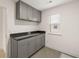 Laundry room with gray cabinets and dark countertop at 13553 Whitman Se Ln, Covington, GA 30014
