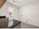 Bright laundry room with dark countertop and window at 13553 Whitman Se Ln, Covington, GA 30014