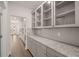 Walk-in pantry with glass-front cabinets and granite countertops at 13553 Whitman Se Ln, Covington, GA 30014