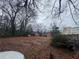 Large backyard with two small red outbuildings and a wheelbarrow at 3453 Woodlawn Cir, Tucker, GA 30084