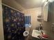 Compact bathroom with a toilet, sink, and patterned shower curtain at 3453 Woodlawn Cir, Tucker, GA 30084