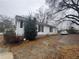 Side view of a one-story home with a gravel driveway and some shrubbery at 3453 Woodlawn Cir, Tucker, GA 30084