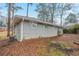 View of the single story gray brick home back exterior with partial yard view at 1658 Hollyhock Ter, Decatur, GA 30032