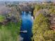 Aerial view of a long pond featuring a dock and surrounding landscape at 5422 Hill Sw Rd, Powder Springs, GA 30127