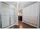 Clean bathroom with shower and bathtub, dark vanity, and hardwood floors at 5422 Hill Sw Rd, Powder Springs, GA 30127