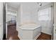 Corner bathroom tub with wood paneling, white trim, and natural light at 5422 Hill Sw Rd, Powder Springs, GA 30127
