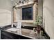 Bathroom vanity with a stone countertop, decorative mirror, and modern lighting at 5422 Hill Sw Rd, Powder Springs, GA 30127