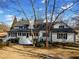 Expansive landscaped yard with mature trees surrounding a large, white home with a black roof at 5422 Hill Sw Rd, Powder Springs, GA 30127
