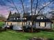 Rear view of a large two-story house featuring a well-maintained lawn and a wrap-around porch at 5422 Hill Sw Rd, Powder Springs, GA 30127