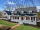 Charming white two-story home featuring a welcoming front porch, red door, and manicured lawn at 5422 Hill Sw Rd, Powder Springs, GA 30127