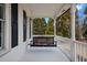 Porch swing on a covered front porch with white railings at 5422 Hill Sw Rd, Powder Springs, GA 30127