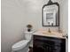 Powder room with dark vanity, decorative mirror, and neutral color palette at 5422 Hill Sw Rd, Powder Springs, GA 30127