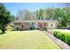 Brick ranch house with landscaped lawn and driveway at 981 Meadowbrook Nw Ln, Conyers, GA 30012