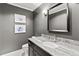 Modern bathroom with gray walls, marble vanity, and a large mirror at 1130 Edgewater Dr, Atlanta, GA 30328