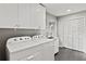 Laundry room with white cabinets, washer, dryer, and exterior access at 1130 Edgewater Dr, Atlanta, GA 30328