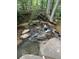 Small waterfall and creek with rocks and trees at 1221 Martin Nash Sw Rd, Lilburn, GA 30047