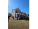 Side view of a brick two-story home with a well-kept lawn and black fencing around the property at 3026 Bridge Walk Dr, Lawrenceville, GA 30044