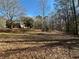 Large backyard with mature trees and a view of the house at 5670 Lanny Dr, Powder Springs, GA 30127