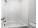 Bright bathroom features white tiled walls surrounding a white tub and shower with modern fixtures at 1026 Cagle Creek Overlook, Canton, GA 30115