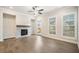 Bright living room features a stone fireplace, ceiling fan, hardwood floors, and natural light at 1026 Cagle Creek Overlook, Canton, GA 30115