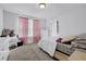 Bright bedroom with carpet, pink curtains, and a white dresser at 1202 Ida Woods Ln, Lawrenceville, GA 30045
