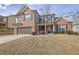 Two story home featuring brick and siding, an attached two car garage, and a covered front porch at 1202 Ida Woods Ln, Lawrenceville, GA 30045