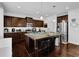 Kitchen with stainless steel appliances, dark wood cabinetry, granite countertops, a kitchen island and hardwood floors at 1202 Ida Woods Ln, Lawrenceville, GA 30045