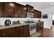 Kitchen with stainless steel appliances, dark wood cabinetry, subway tile backsplash and granite countertops at 1202 Ida Woods Ln, Lawrenceville, GA 30045