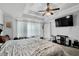Spacious main bedroom features a ceiling fan, TV, neutral carpet, and an ensuite bathroom at 1202 Ida Woods Ln, Lawrenceville, GA 30045