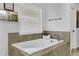 Soaking tub with window, tile surround, and chrome fixtures at 1202 Ida Woods Ln, Lawrenceville, GA 30045