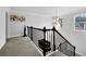 Elegant staircase featuring a dark wooden railing and a modern chandelier at 1202 Ida Woods Ln, Lawrenceville, GA 30045