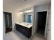 Bathroom with dual sinks, dark vanity, framed mirror, and tile flooring at 262 Depot Landing Rd # 51, Auburn, GA 30011