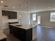 Open kitchen with granite countertops, stainless steel sink, pendant lighting, and dark cabinets at 262 Depot Landing Rd # 51, Auburn, GA 30011