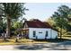 White farmhouse with red roof, surrounded by lush greenery at 262 Depot Landing Rd # 51, Auburn, GA 30011