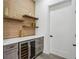 Custom wet bar area with wooden accent wall, wine cooler, floating shelves, and gray cabinets at 467 Concord Sw Rd, Smyrna, GA 30082