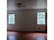 Bright bedroom with hardwood floors and two windows at 1604 Pine Tree Trl, Atlanta, GA 30349