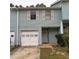 Light blue two-story townhouse with white garage door and shutters at 1604 Pine Tree Trl, Atlanta, GA 30349