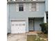 Light blue two-story townhouse with white garage door and shutters at 1604 Pine Tree Trl, Atlanta, GA 30349