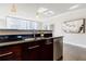 Kitchen island with stainless steel sink, dark wood cabinets, black counters, and pendant lighting at 20 10Th Nw St # 901, Atlanta, GA 30309