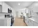 Modern kitchen with white cabinets, quartz countertops, and stainless steel appliances at 495 Ashley Way, Loganville, GA 30052