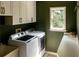 Bright laundry room with white cabinets, and green walls at 255 Grogans Lake Pt, Atlanta, GA 30350