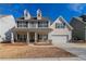 Two story house with beige siding, stone accents, and a two car garage at 2839 Suttonwood Way, Buford, GA 30519